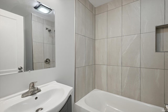 bathroom featuring tiled shower / bath combo and vanity