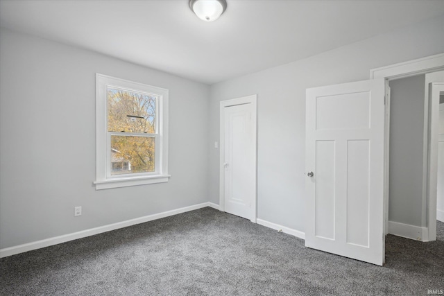 unfurnished bedroom with dark carpet