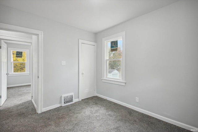 empty room with a healthy amount of sunlight and carpet floors