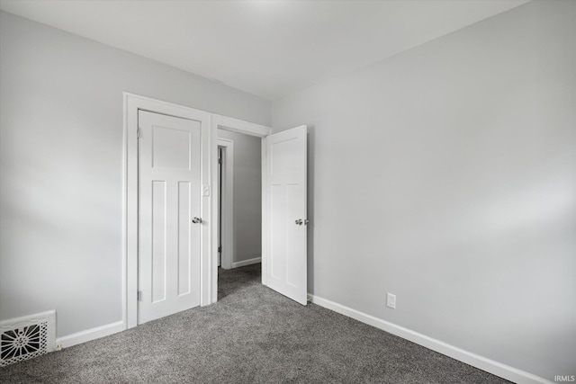 unfurnished bedroom with dark colored carpet