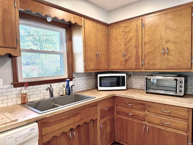 kitchen with white appliances, sink, and tasteful backsplash