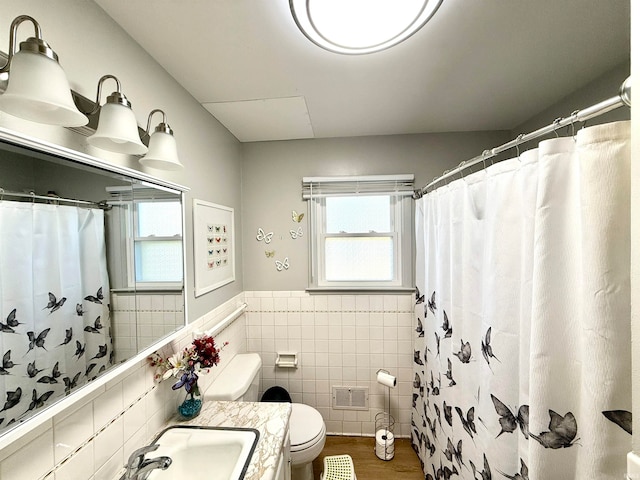 bathroom featuring tile walls, hardwood / wood-style flooring, toilet, and a shower with curtain