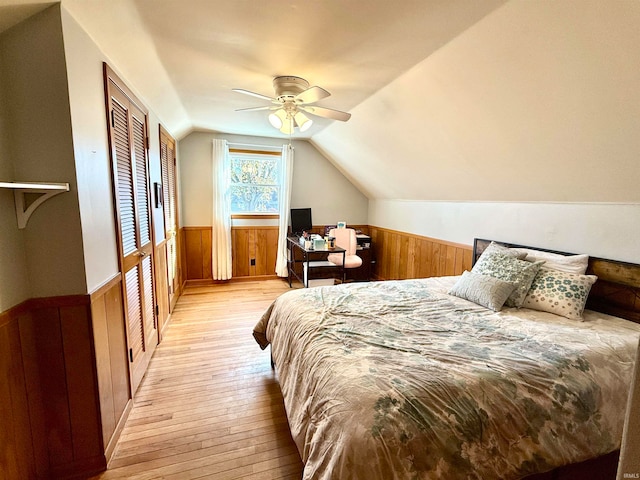 bedroom with light hardwood / wood-style floors, lofted ceiling, and ceiling fan