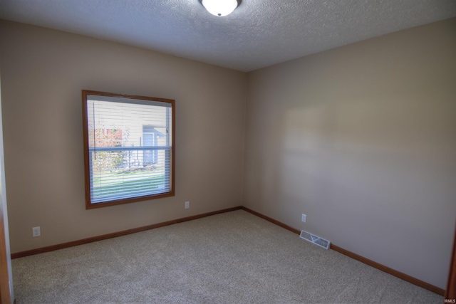 unfurnished room with light colored carpet and a textured ceiling