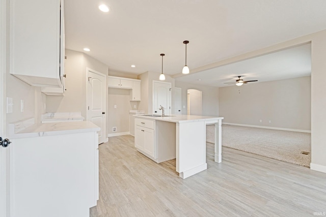 4805 Falcon Pkwy, New Haven, IN 46774 - kitchen featuring a sink, baseboards, ceiling fan, arched walkways, and a center island with sink