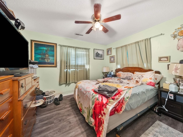 bedroom featuring a textured ceiling, ceiling fan, and dark hardwood / wood-style floors