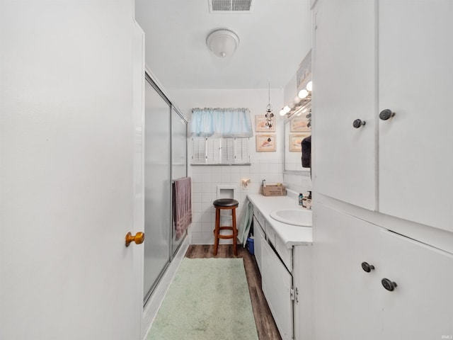 bathroom featuring vanity, a shower with door, and hardwood / wood-style flooring