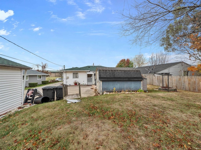 back of house with a shed and a yard