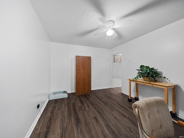 home office featuring a textured ceiling, ceiling fan, and dark hardwood / wood-style floors