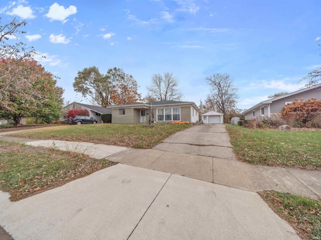 view of front of house with a garage, a front yard, and an outdoor structure