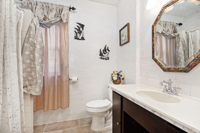 bathroom featuring toilet, vanity, and tile patterned flooring