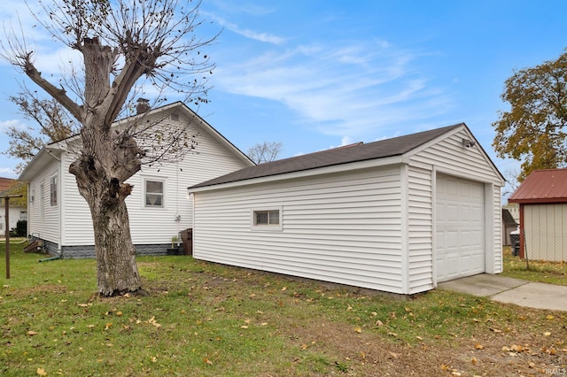 view of property exterior featuring a lawn, a garage, and an outdoor structure