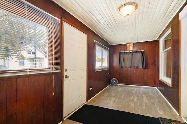 doorway featuring wood walls and light wood-type flooring