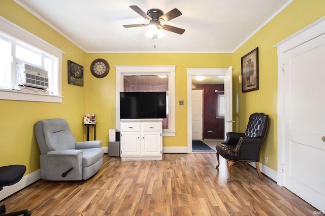 living area with ornamental molding, light hardwood / wood-style floors, and ceiling fan