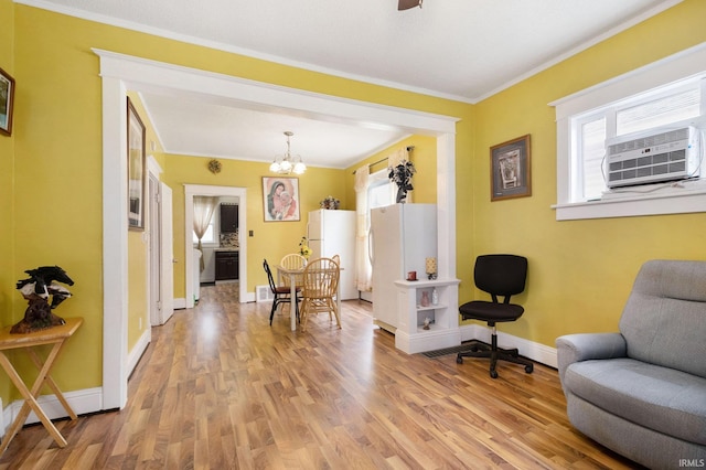 sitting room featuring wood-type flooring, a notable chandelier, and ornamental molding