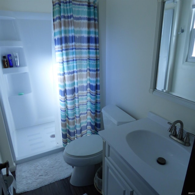 bathroom with walk in shower, vanity, toilet, and wood-type flooring