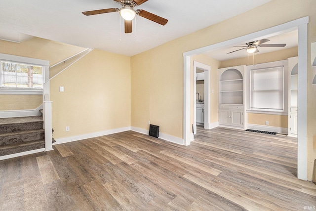 unfurnished living room with hardwood / wood-style floors, built in features, and ceiling fan