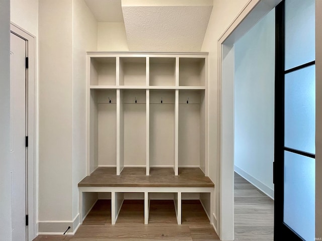 mudroom with hardwood / wood-style flooring and a textured ceiling