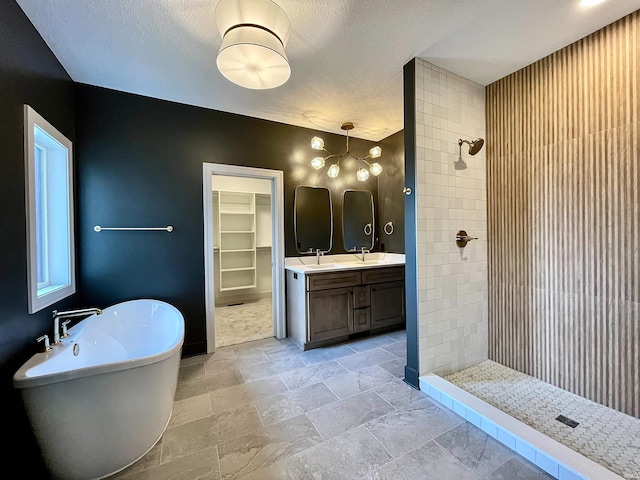 bathroom featuring shower with separate bathtub, a textured ceiling, and vanity