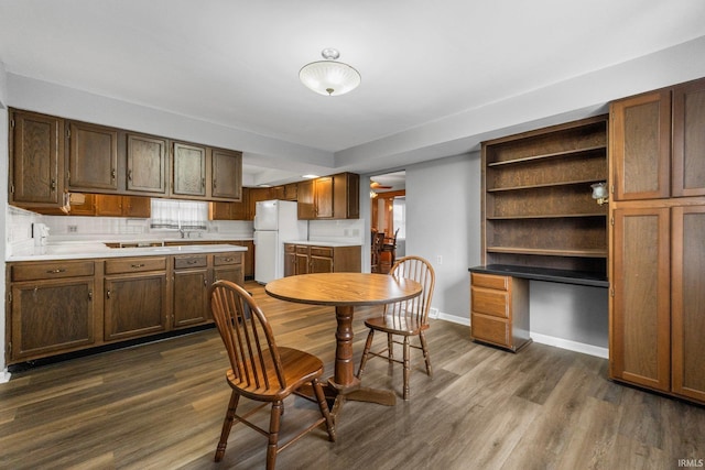 kitchen with dark wood-type flooring, sink, backsplash, and white fridge