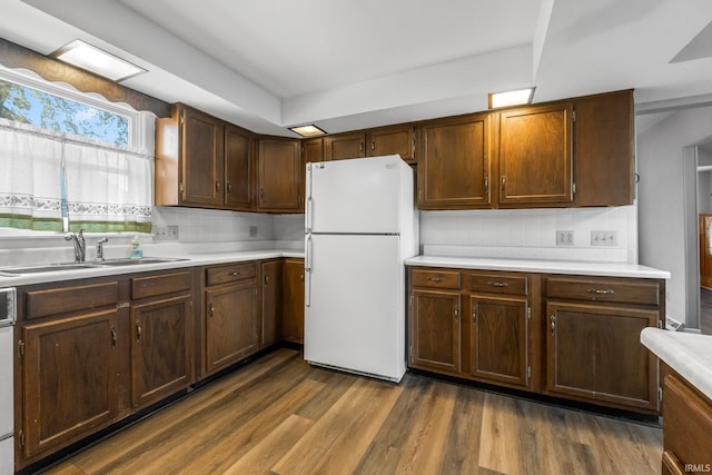 kitchen with white appliances, sink, backsplash, and dark hardwood / wood-style flooring