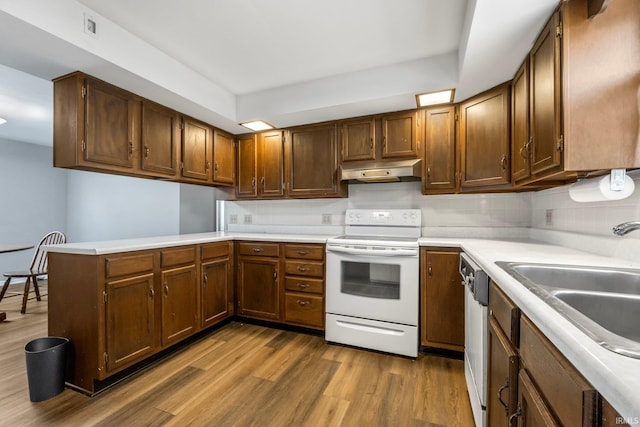 kitchen featuring electric stove, sink, hardwood / wood-style flooring, dishwasher, and kitchen peninsula