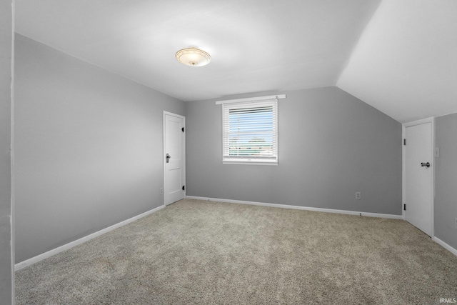 bonus room featuring light carpet and vaulted ceiling