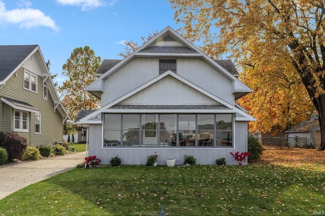 view of front facade with a sunroom and a front yard