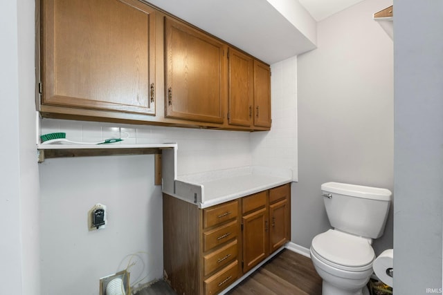 bathroom with toilet, decorative backsplash, and hardwood / wood-style flooring