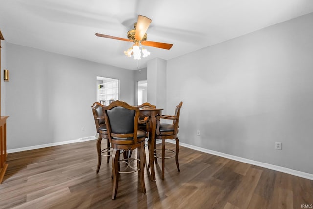 dining area with dark wood-type flooring and ceiling fan