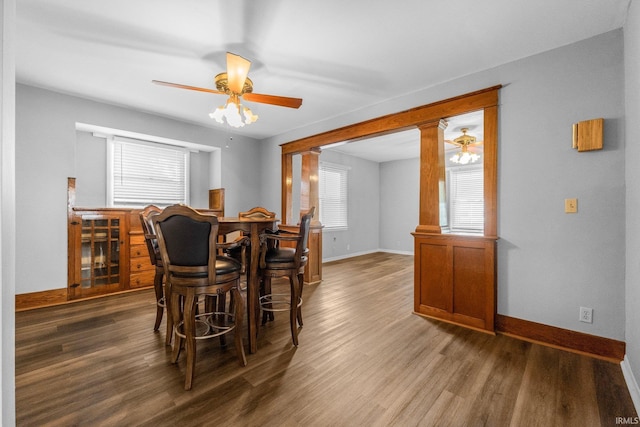 dining area featuring dark hardwood / wood-style flooring, ceiling fan, ornate columns, and plenty of natural light