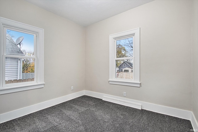 spare room featuring a baseboard radiator and carpet