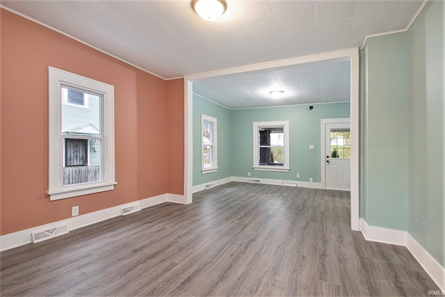 empty room featuring crown molding and dark hardwood / wood-style flooring