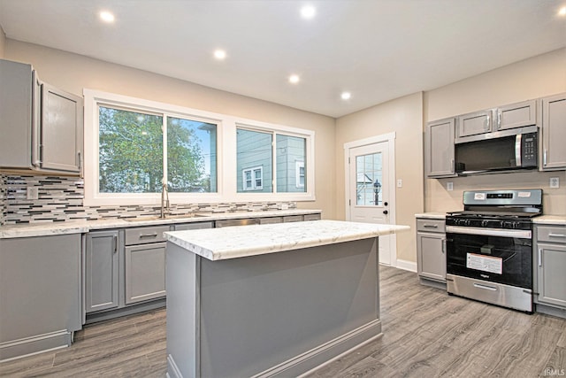 kitchen with gray cabinets, stainless steel appliances, and a kitchen island