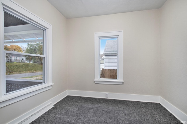 empty room with plenty of natural light, carpet flooring, and a baseboard radiator