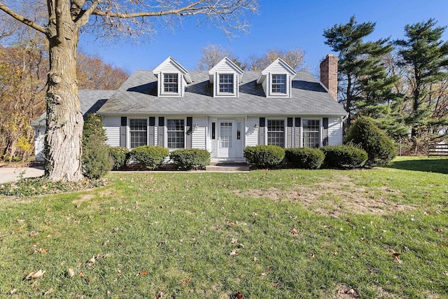 cape cod home with a front lawn