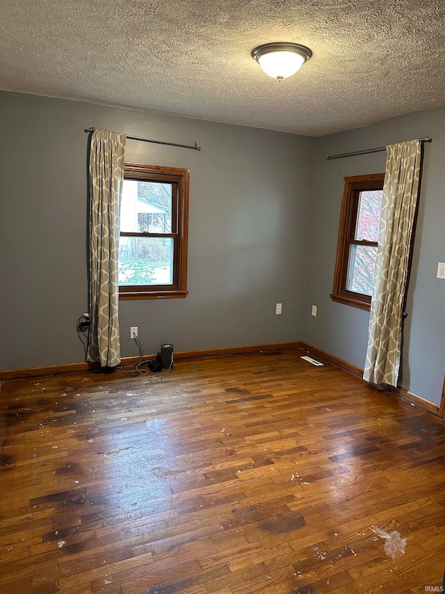 spare room with dark wood-type flooring and a textured ceiling