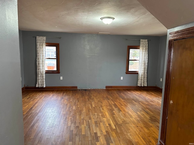 unfurnished room featuring hardwood / wood-style flooring and a healthy amount of sunlight