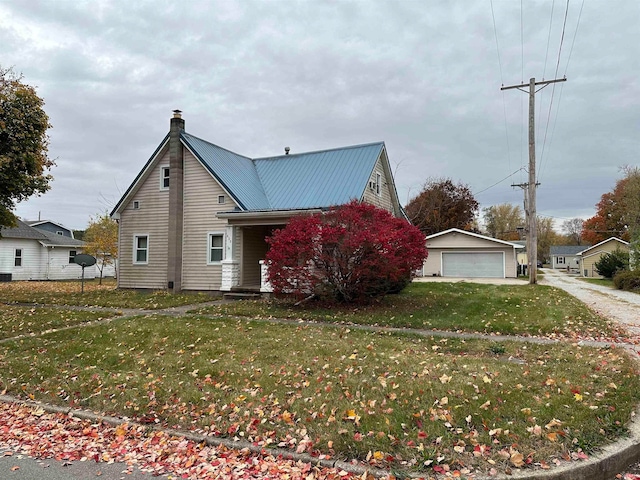 view of front facade featuring an outbuilding, a front yard, and a garage