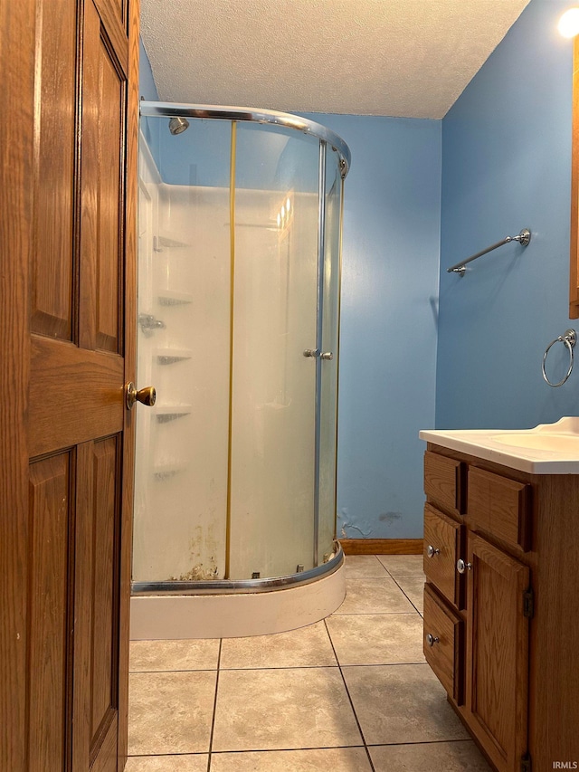 bathroom with a textured ceiling, tile patterned floors, and a shower with shower door