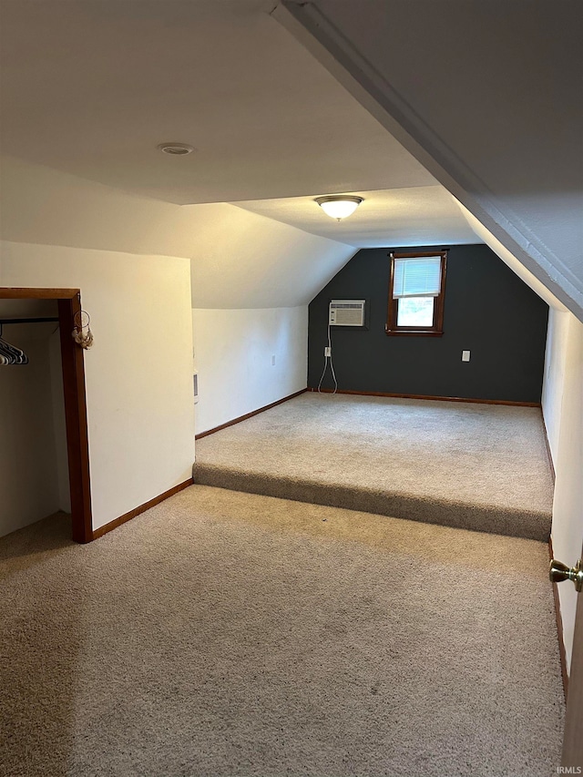 bonus room featuring carpet floors, lofted ceiling, and a wall mounted air conditioner