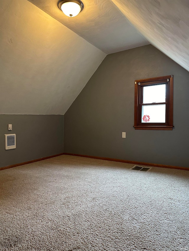 additional living space with carpet flooring and lofted ceiling