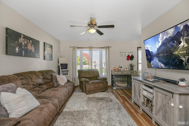 living room featuring hardwood / wood-style floors and ceiling fan