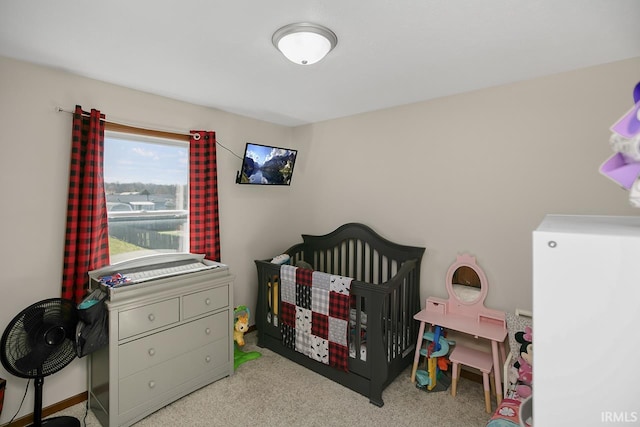 bedroom featuring a nursery area and light carpet