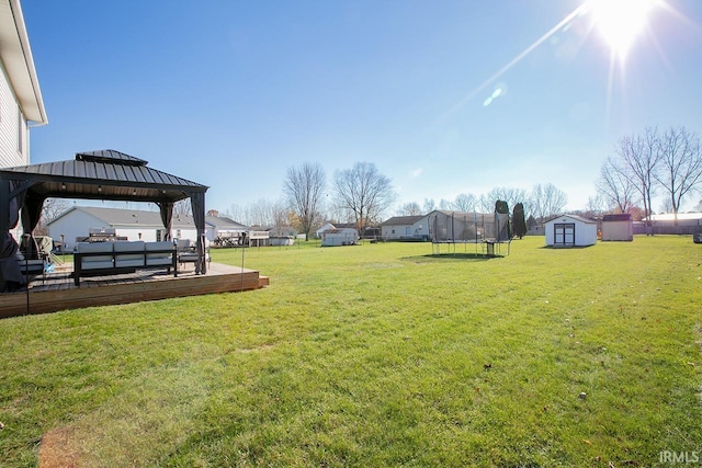 view of yard featuring a shed, a trampoline, and a gazebo