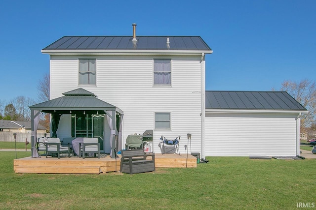 rear view of property with a yard, a gazebo, and a wooden deck