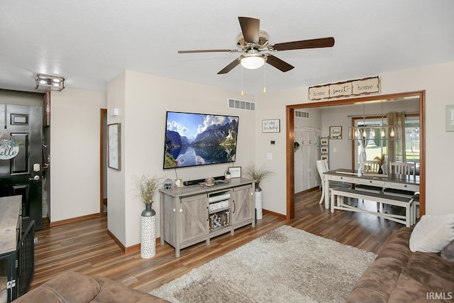 living room with dark wood-type flooring and ceiling fan