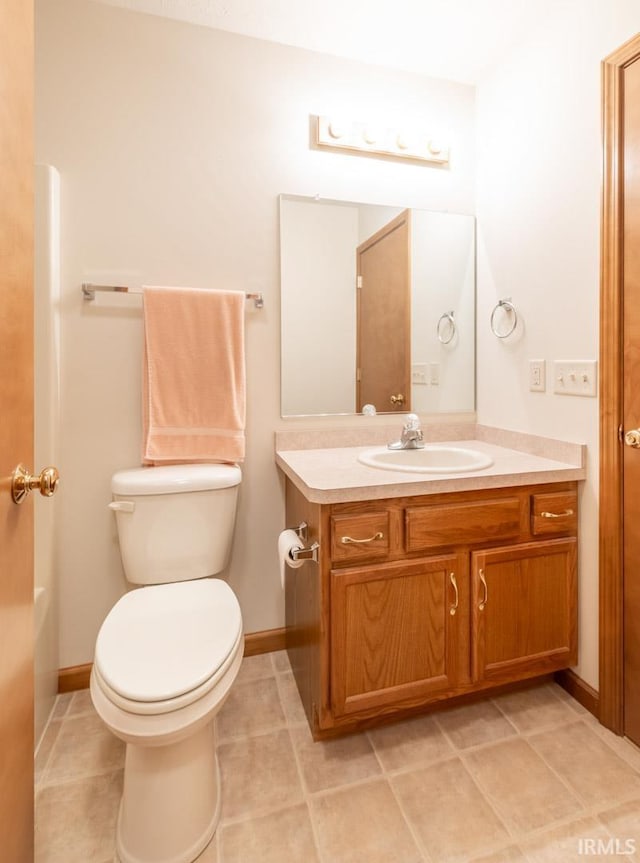 bathroom featuring tile patterned flooring, vanity, and toilet