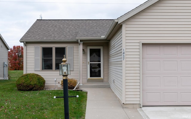 property entrance with a garage and a lawn