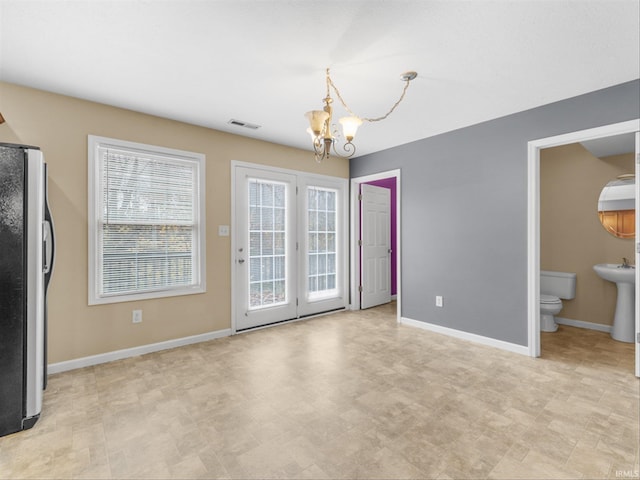 unfurnished dining area with a chandelier